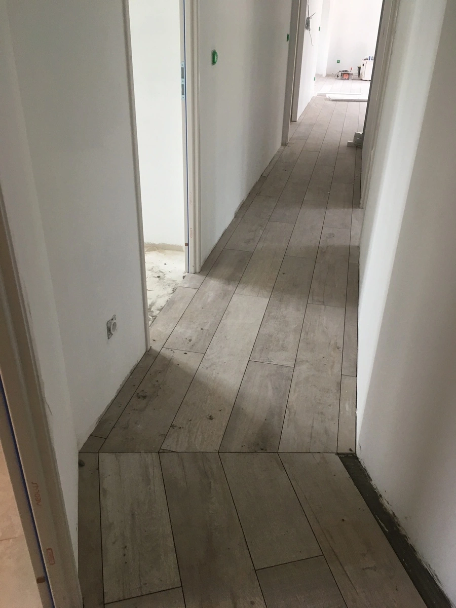 Pose de carrelage dans un couloir d'une maison en construction ou en rénovation